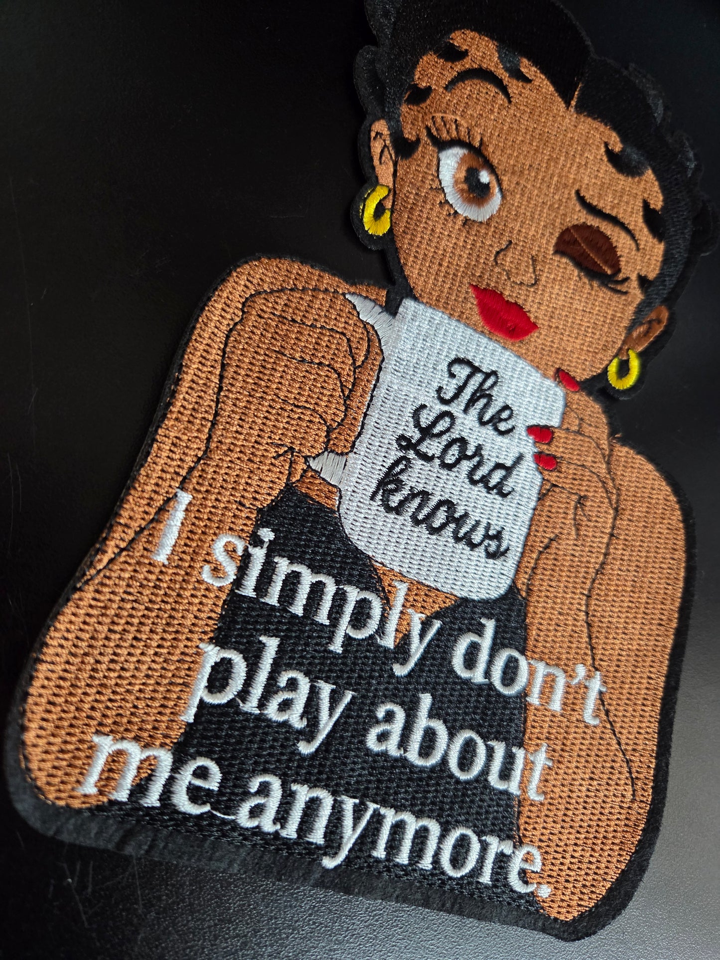 Winking Betty - The Lord Knows Iron On Patch